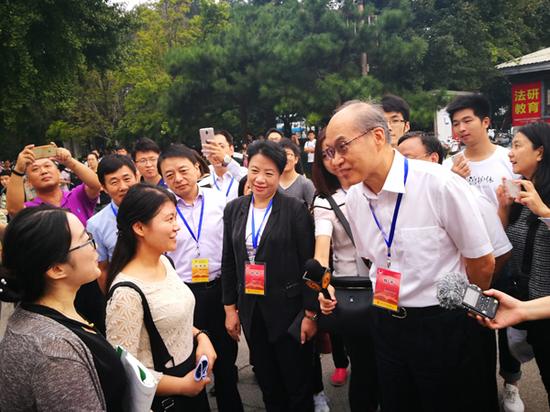 张军部长在考场外与考生亲切交流，并送上祝福。